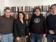 Studenci Koła Naukowego Tradycji Prawa Rzymskiego z dr BJ Kowalczyk na w tle regał z książkami